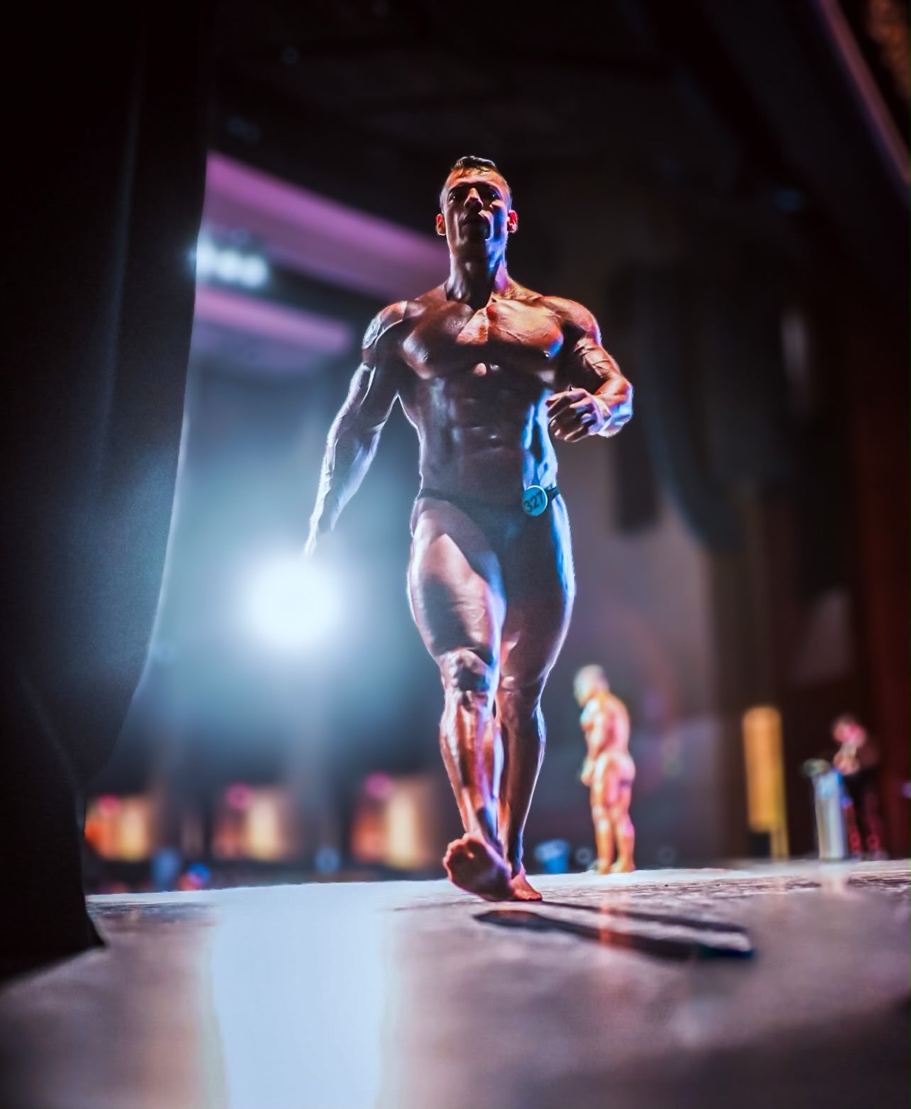 Gio Melchor walking onto the bodybuilding stage